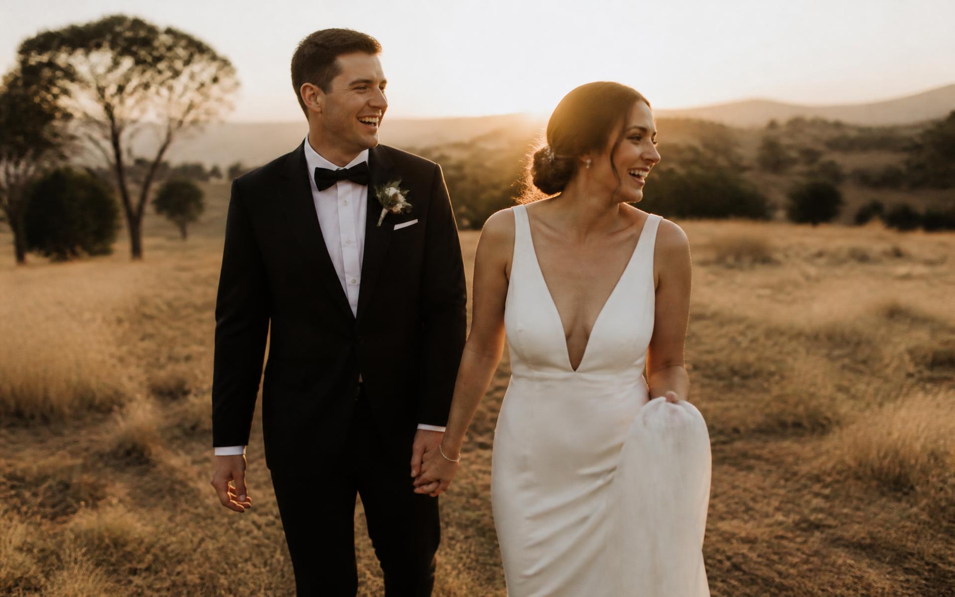Bride and groom walking through golden hour light at their wedding